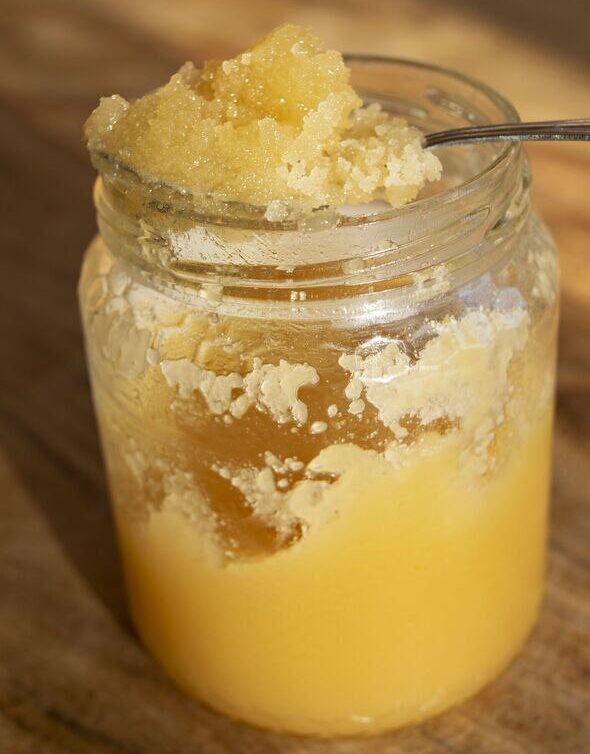 یک شیشه عسل رس زده طبیعی که فرایند کریستالیزاسیون را نشان می‌دهد